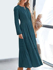 White V-neck pleated waist tiered long-sleeved dress by FJØRNA, featuring a flowing design and elegant silhouette.