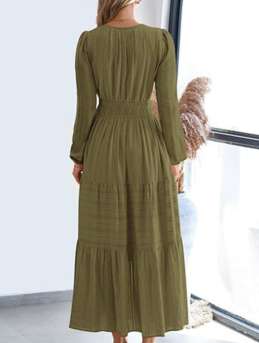 FJØRNA white V-neck pleated waist tiered long-sleeved dress displayed on a hanger with a focus on the dress details.