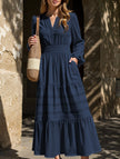 FJØRNA white V-neck pleated waist tiered long-sleeved dress, featuring elegant design and flowing fabric.
