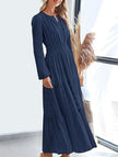 FJØRNA navy V-neck pleated waist tiered long-sleeved dress, elegant and flowy with a stylish silhouette.