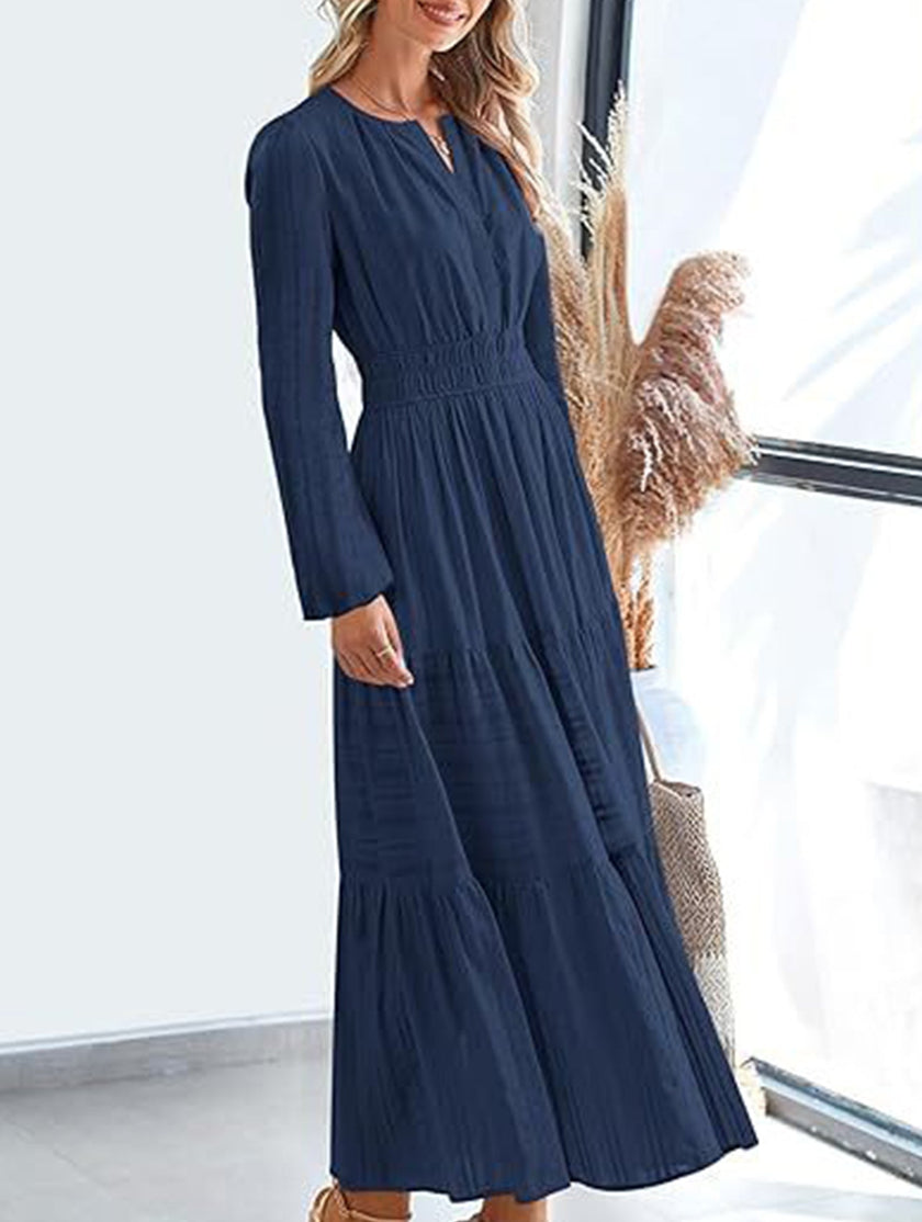 FJØRNA navy V-neck pleated waist tiered long-sleeved dress, elegant and flowy with a stylish silhouette.