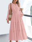 White V-neck pleated waist tiered long-sleeved dress by FJØRNA, featuring flowing fabric and elegant design.