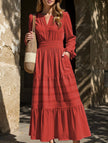 White V-neck pleated waist tiered long-sleeved dress by FJØRNA with flowing fabric and elegant design.