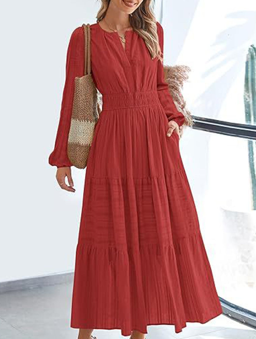 White V-neck pleated waist tiered long-sleeved dress by FJØRNA with flowing fabric and elegant design.