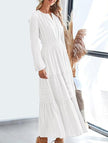 White FJØRNA V-neck pleated waist tiered long-sleeved dress with flowing fabric and elegant design.