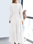White V-neck pleated waist tiered long-sleeved dress by FJØRNA, showcasing its flowy fabric and elegant design.