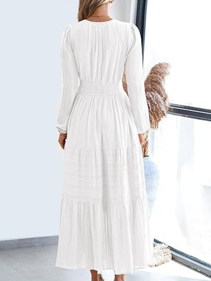 White V-neck pleated waist tiered long-sleeved dress by FJØRNA, showcasing its flowy fabric and elegant design.