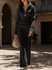 Black zipper slim fit long dress by FJØRNA featuring a sleek design and elegant silhouette.