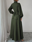 White FJØRNA long-sleeved dress with a simple, elegant design, shown hanging on a model with a neutral background.