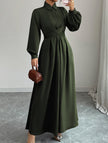 White FJØRNA long-sleeved dress with a simple, elegant design, displayed on a hanger against a neutral background.