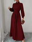 White FJØRNA long-sleeved dress with a simple, elegant design, displayed on a hanger against a neutral background.