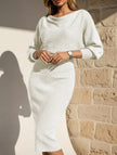 White FJØRNA elegant slim fit knit dress displayed on a hanger, showcasing its sleek design and fine knit texture.