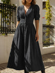 Black FJØRNA deep V-neck fitted shirt dress with long sleeves and tailored silhouette, displayed on a hanger.