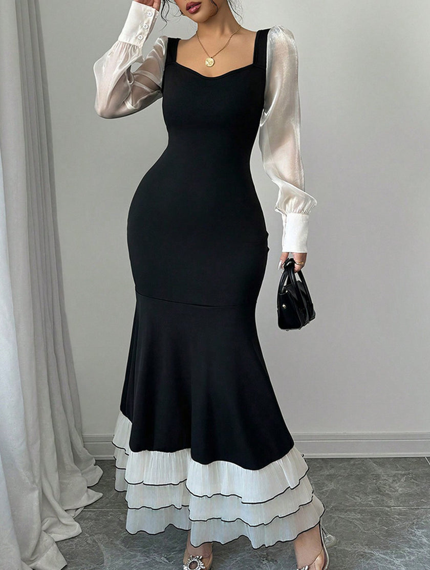 FJØRNA colorblock long sleeve mermaid dress in black and white, fitted silhouette with elegant design and stylish color blocking.