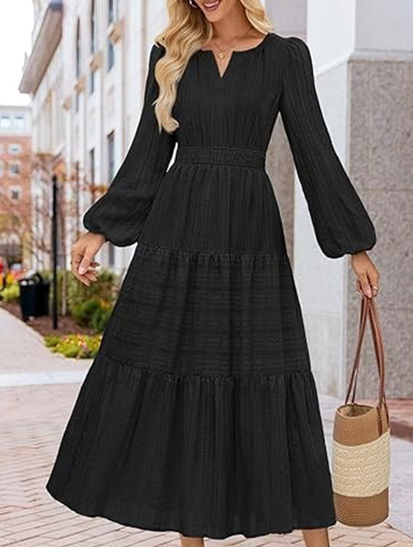 FJØRNA white V-neck tiered puff sleeve maxi dress displayed on a hanger, showcasing its flowing fabric and elegant design.