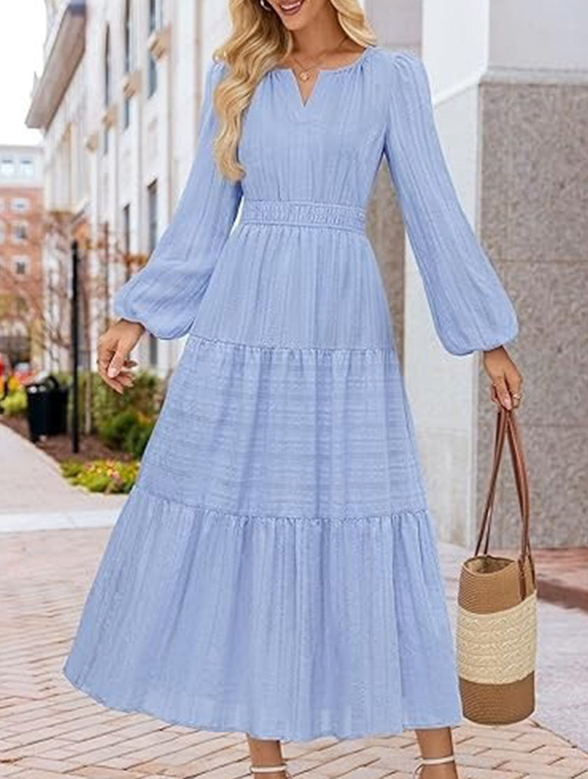 FJØRNA white V-neck tiered puff sleeve maxi dress displayed on model, showcasing flowing fabric and stylish design.