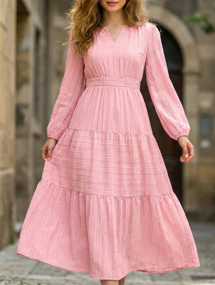 FJØRNA white V-neck tiered puff sleeve maxi dress displayed on a hanger, showcasing its flowing fabric and elegant design.
