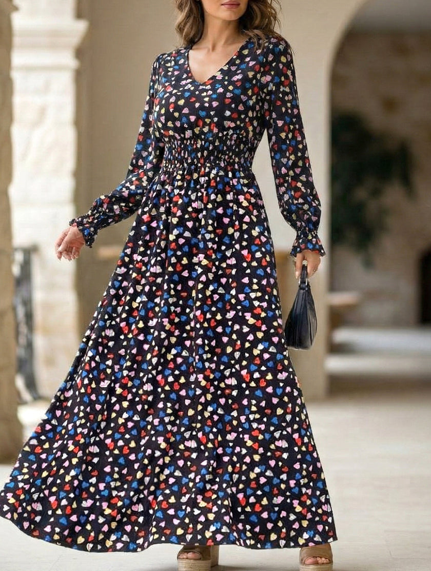 Women's printed V-neck full skirt dress by FJØRNA in white with black floral pattern, displayed on a model.