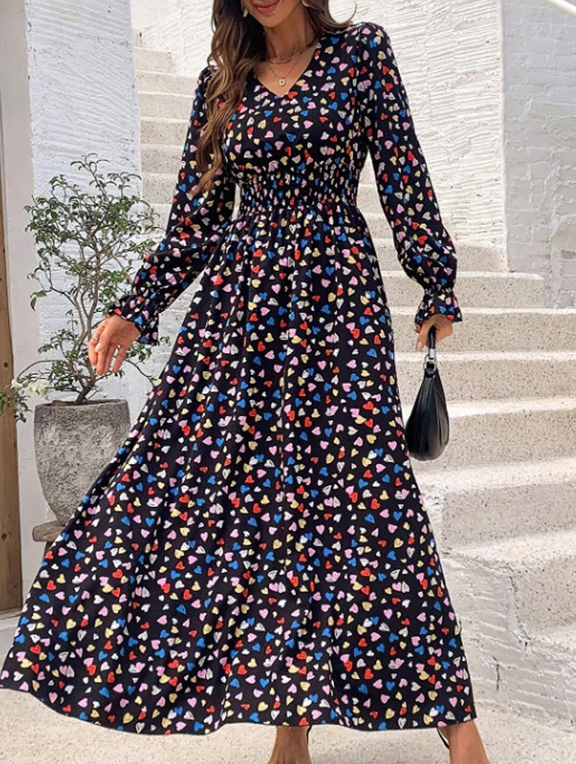 Women's printed V-neck full skirt dress by FJØRNA, featuring a stylish design and flowing silhouette in black fabric.