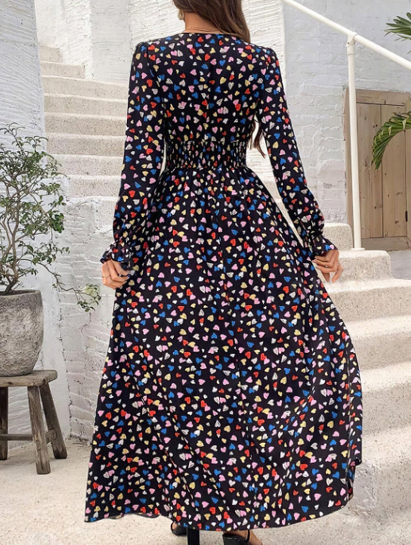 Women's printed V-neck full skirt dress by FJØRNA, featuring a stylish design and flowing silhouette in black.
