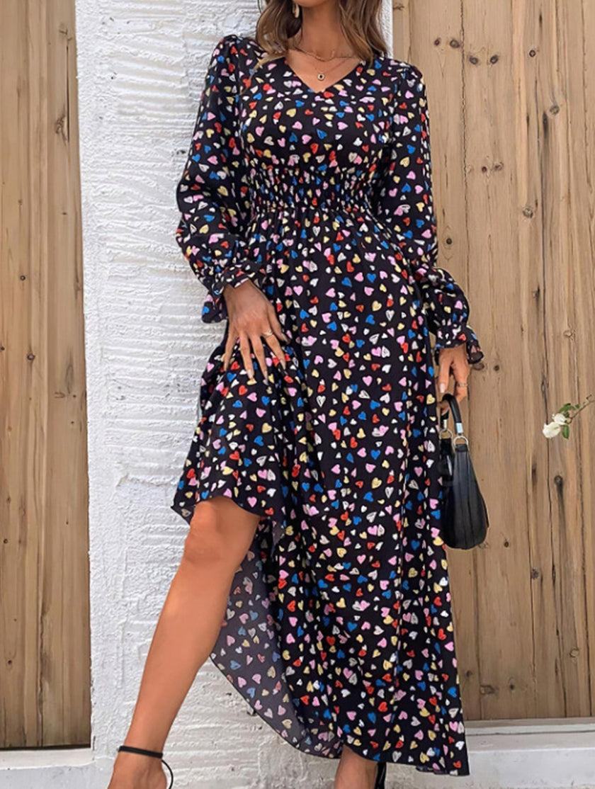 Women's printed V-neck full skirt dress by FJØRNA, featuring a stylish design and flowing silhouette, in black fabric.