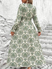 Women's printed V-neck full skirt dress by FJØRNA, featuring a stylish white design and flowing fabric.