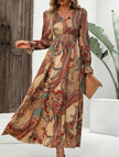 Women's printed V-neck full skirt dress by FJØRNA in white, featuring a stylish pattern and flowing silhouette.