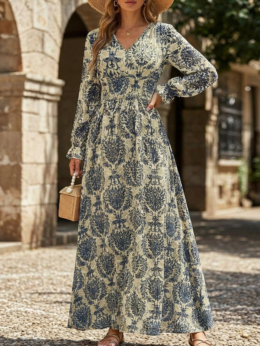 FJØRNA vintage print white V-neck long sleeve maxi dress, elegant and flowing, hanging on a hanger against a plain background.