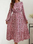 White floral high waist long sleeve midi dress by FJØRNA, showcasing elegant design and flowy fabric in a stylish pose.