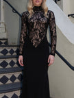 Black lace hollow mock neck bodycon dress by FJØRNA featuring intricate lace details and a fitted silhouette.