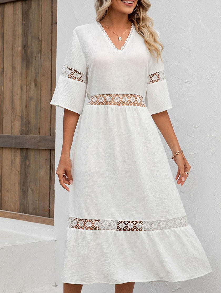 White V-neck hollow short sleeve dress by FJØRNA, showcasing its elegant neckline and flowing fabric.