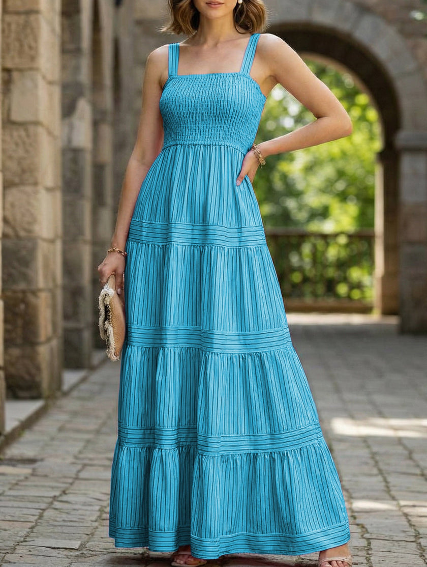 FJØRNA retro striped maxi dress in white with blue stripes, flowing length, and sleeveless design, perfect for casual summer wear.