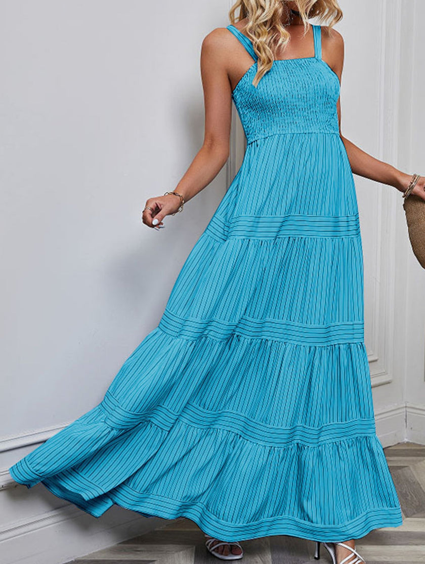 Blue retro-style striped maxi dress by FJØRNA, featuring a flowing design and bold horizontal stripes in a full-length dress style.