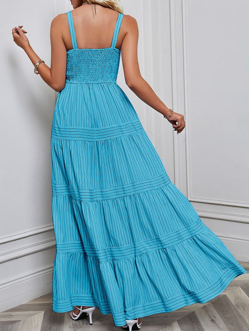 Blue retro-style striped maxi dress by FJØRNA featuring a flowing silhouette and white accents, perfect for casual or summer wear.