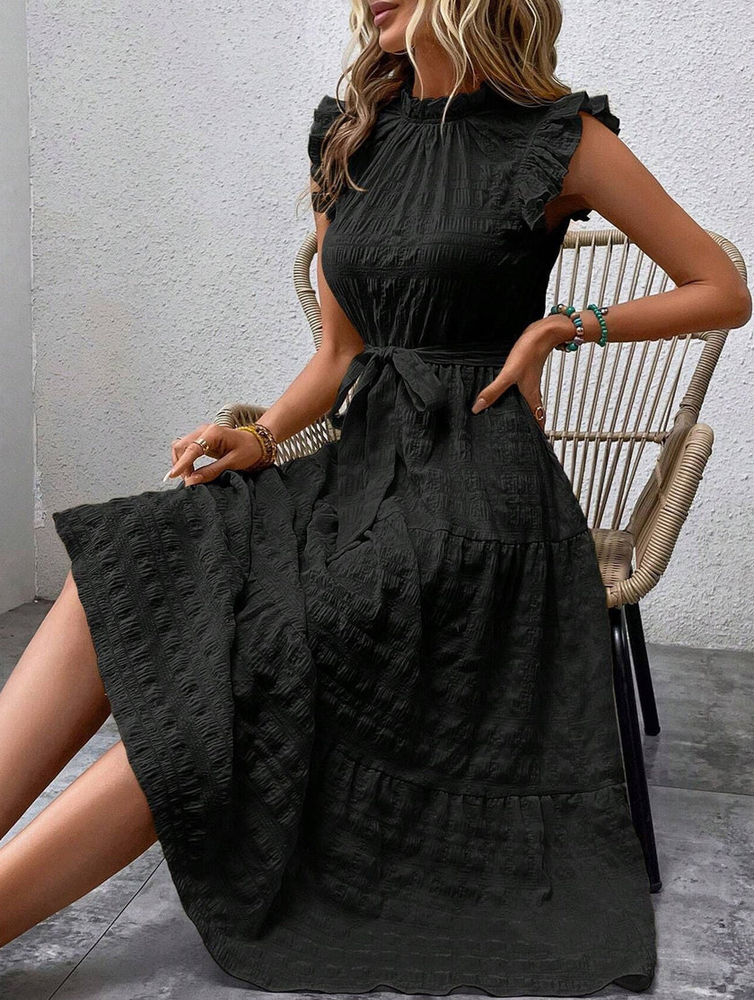 Black FJØRNA ruffled flutter sleeve tie textured dress, elegant design with layered ruffles and soft fabric details.