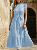 Light blue FJØRNA ruffled flutter sleeve tie textured dress displayed on a model, showcasing its flowing fabric and elegant design.