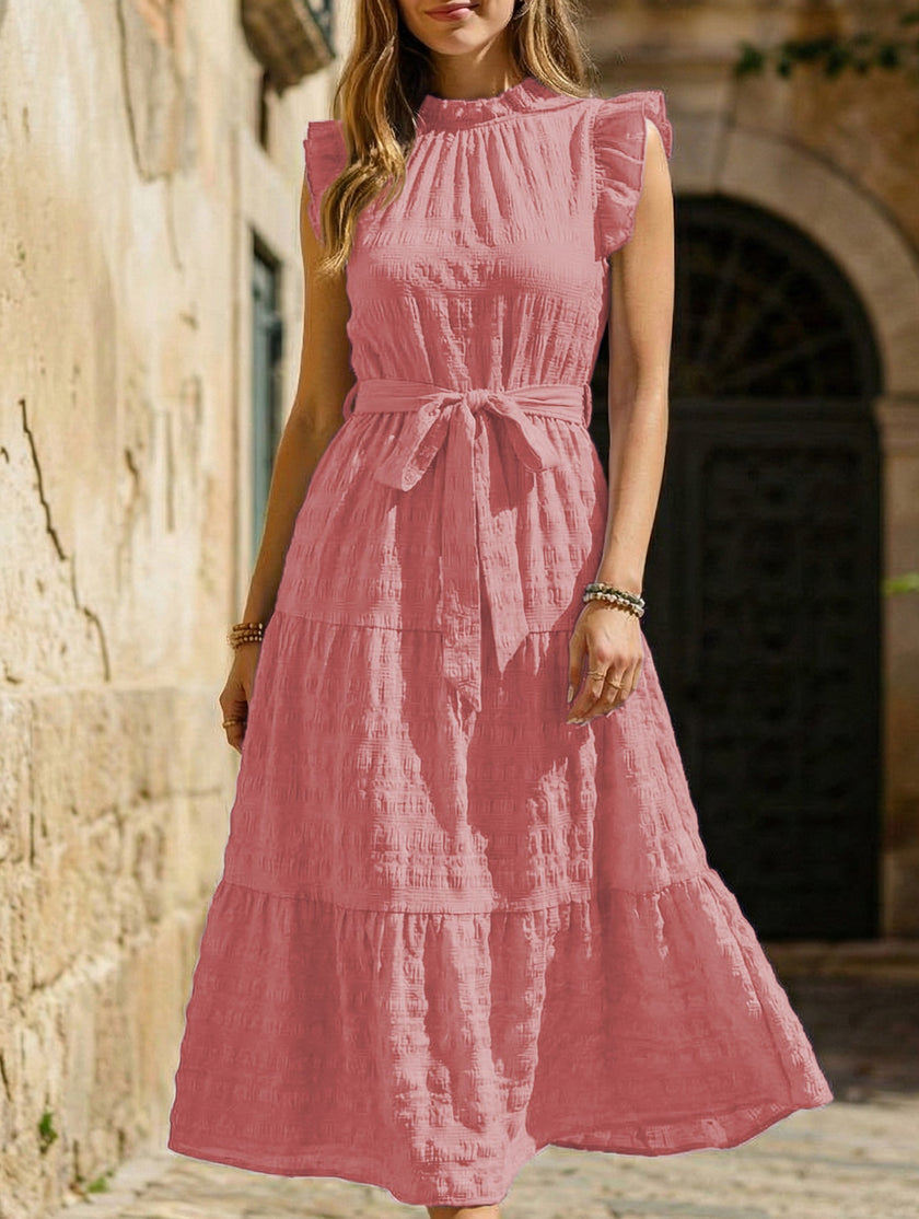 White FJØRNA ruffled flutter sleeve tie textured dress, showing soft fabric, ruffle details, and elegant silhouette.