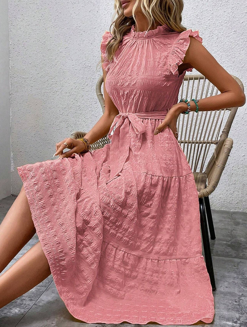 White FJØRNA ruffled flutter sleeve tie textured dress, showcasing its delicate ruffles and elegant design.