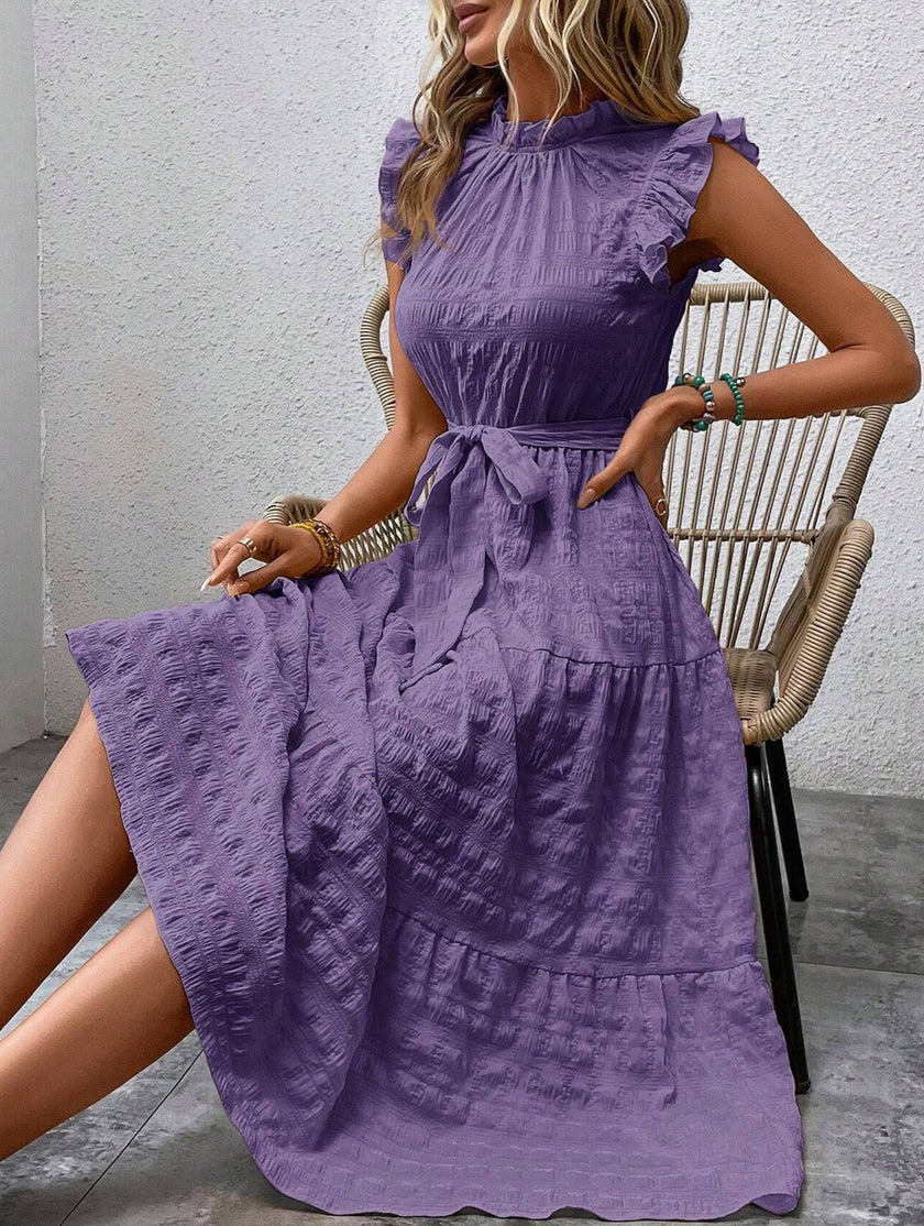 FJØRNA white ruffled flutter sleeve tie-textured dress, elegant and stylish, shown in a close-up image.