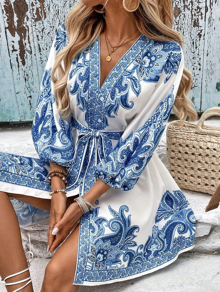 Blue printed V-neck three-quarter sleeve tie-waist dress by FJØRNA, showcasing a stylish silhouette and elegant design.