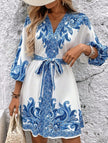 FJØRNA printed white V-neck three-quarter sleeve tie-waist dress with floral pattern, displayed on a hanger.