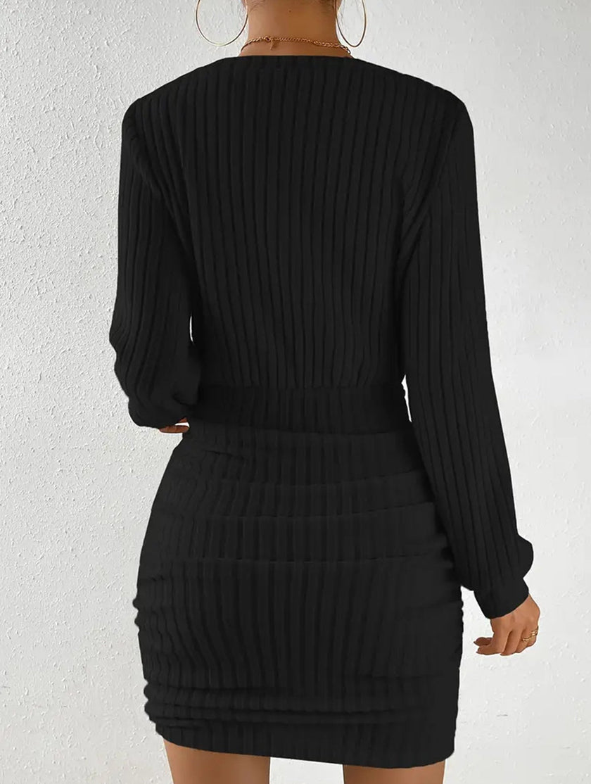Black brushed ribbed V-neck long-sleeved bodycon dress by FJØRNA, close-up of fitted design and textured fabric.