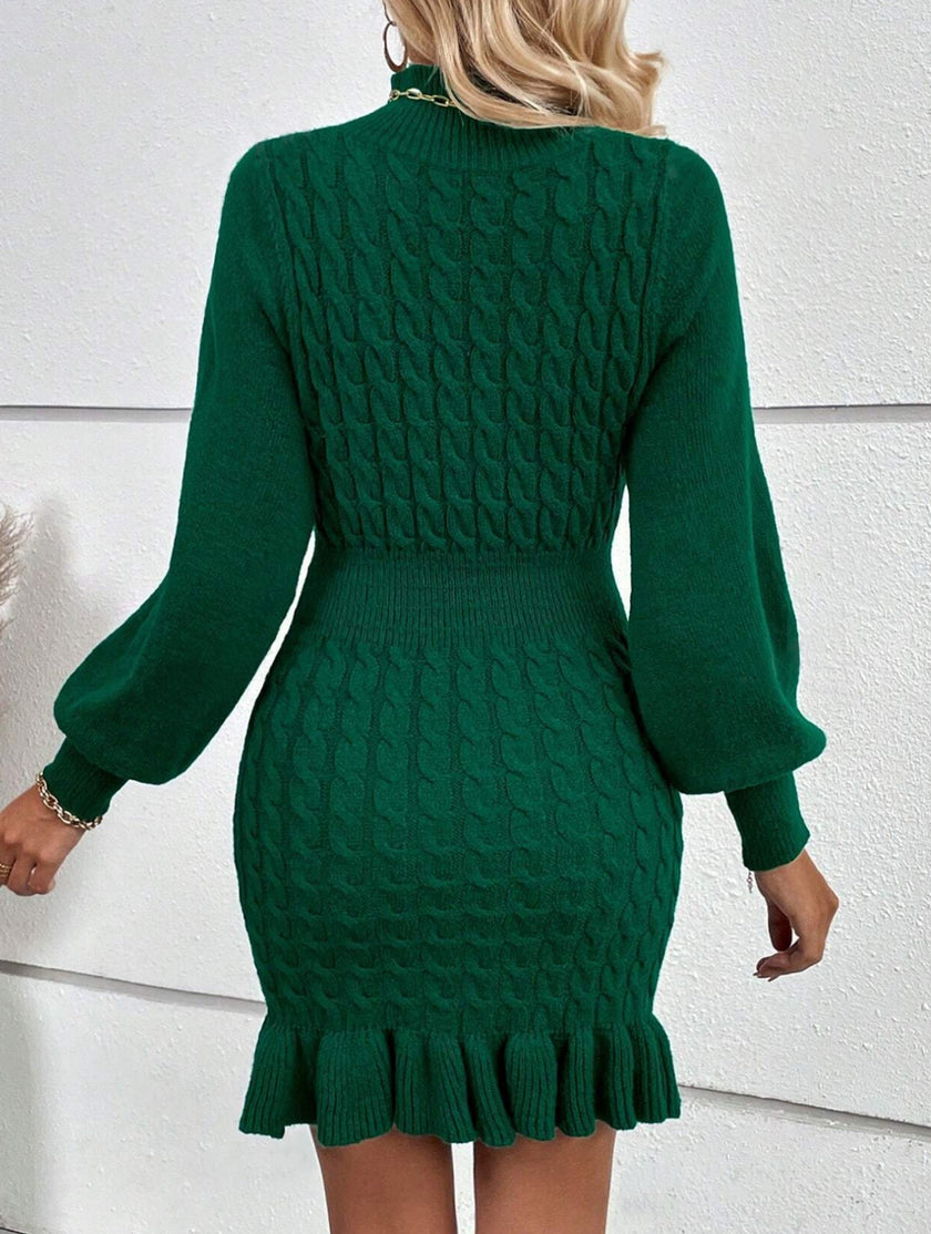 Green FJØRNA cable knit waist-cinching sweater dress, stylish and fitted, showcasing its cozy texture and flattering silhouette.