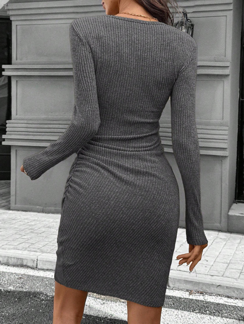 FJØRNA white knitted slim-fit long-sleeved dress displayed on a mannequin, showcasing its stylish design and fitted silhouette.