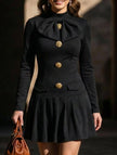 Black high-neck bow button dress by FJØRNA, featuring a stylish design with a fitted silhouette and elegant details.