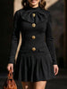 Black high-neck bow button dress by FJØRNA, featuring a stylish design with a fitted silhouette and elegant details.