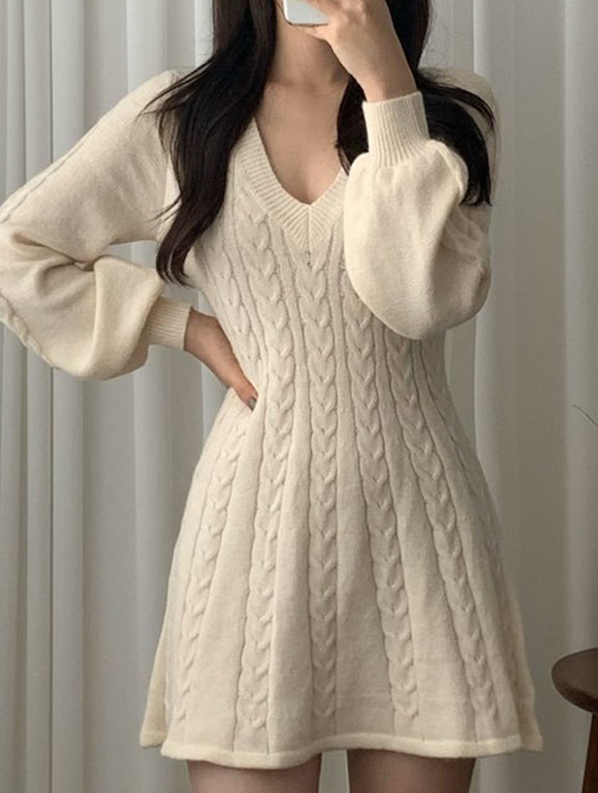 White FJØRNA retro cable knit V-neck fitted dress displayed on a hanger, showcasing its textured knit pattern and classic silhouette.