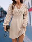 White crochet V-neck A-line beach dress by FJØRNA with intricate knit details and a flowing silhouette.