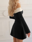 FJØRNA off-shoulder black bell sleeve dress with flowing fabric and fitted waist, styled for elegant occasions.