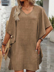 White FJØRNA solid loose ruffle V-neck flowy dress hanging on a rack with soft fabric texture and ruffle details.